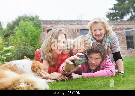 Vater Fotografieren Familie liegen auf Rasen Stockfoto