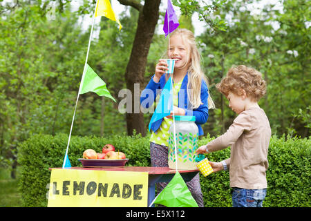 Geschwister bei ihrer Limonade stehen in ihrem Garten Stockfoto