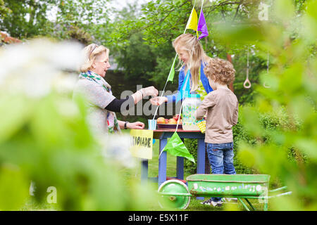 Großmutter, die Limonade von Enkel Stand kaufen Stockfoto