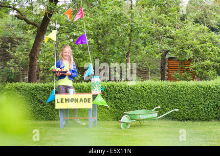 Limonade stehen Mädchen mit Schale von Äpfeln hinter ihr stehen Stockfoto