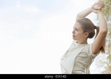 Junge Frau streckte die Arme vor dem Training Stockfoto