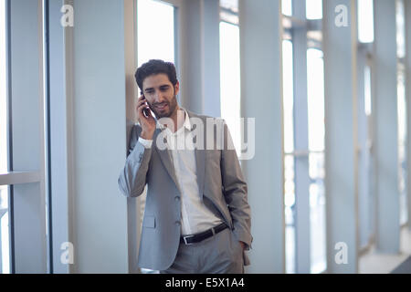 Jungunternehmer im Chat auf Smartphone im Tagungszentrum Stockfoto