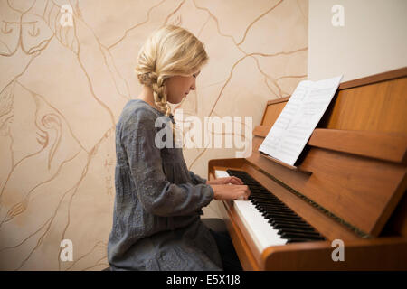 Porträt eines Mädchens mit dem Klavierspiel im Speisesaal Stockfoto