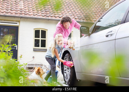 Mädchen half Vater sein Auto waschen Stockfoto