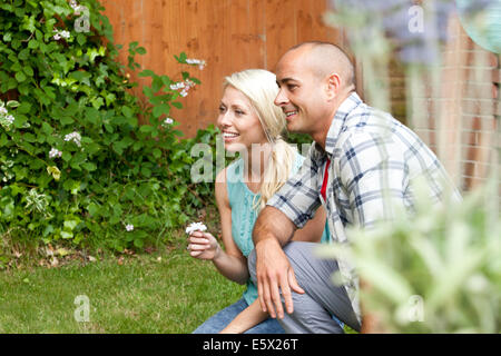 Paar hockend unten im Garten beobachten Stockfoto