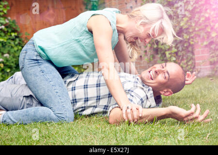 Glückliches Paar spielen kämpfen im Garten Stockfoto