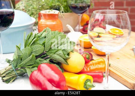 Stillleben mit Gartentisch mit Kräutern, Obst, Gemüse und Rotwein Stockfoto