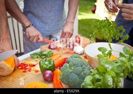 Schuss von drei männliche Freunde, die Zubereitung von Speisen für Gartengrill beschnitten Stockfoto