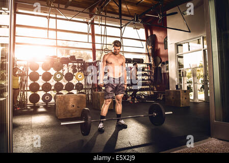 Bodybuilder blickte auf Langhantel im Fitness-Studio Stockfoto