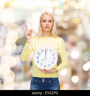 Student mit Wanduhr und finger Stockfoto