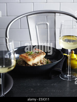 Schüssel mit Pfanne gebratenen Red Snapper mit Kraut Beilage auf einem Bett aus wilden risotto Stockfoto