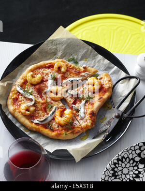 In Scheiben geschnitten Meeresfrüchte Pizza mit weißen Sardellen, Garnelen, Olivenöl und Dill garnieren Stockfoto