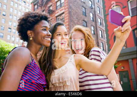 Drei junge Frauen, die die Bild von sich selbst mit dem Handy Stockfoto