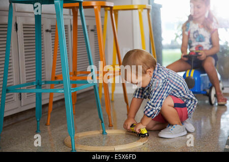 Männliche Kleinkind und Schwester spielen in Küche Stockfoto