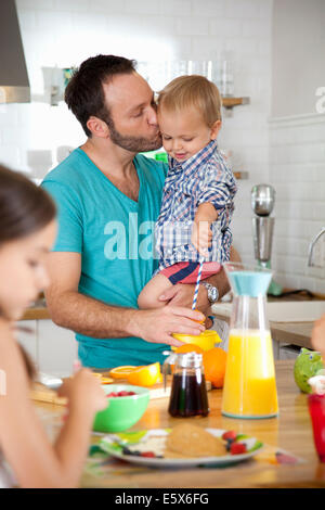 Mitte erwachsener Mann-Multitasking-Frühstück mit Sohn und Tochter Stockfoto
