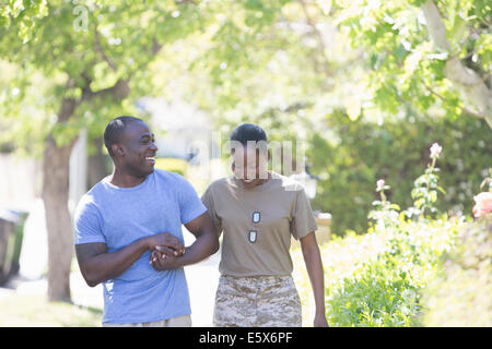 Soldatin Mannes Hand haltend, auf Heimkehr beim Spaziergang Stockfoto