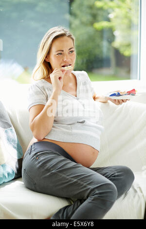 Schwangere Frau Essen snack Stockfoto