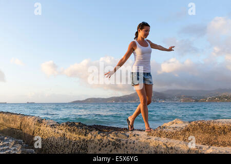 Mitte Erwachsene Frau zu Fuß entlang der Pier, Spice Island Beach Resort, Grenada, Caribbean Stockfoto