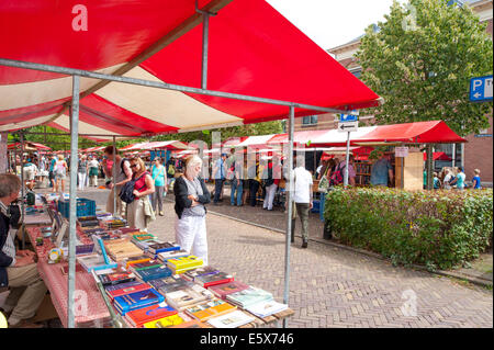 Das rote weiße farbige Buch steht voller gebrauchte und antiquarische Bücher und voll mit shopping Menschen umzusehen. Stockfoto