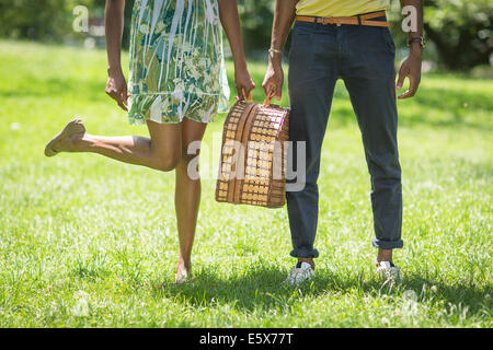 Abgeschnitten Bild des jungen Paares mit Picknick-Korb im park Stockfoto