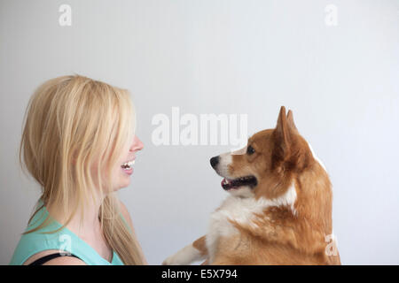 Porträt von niedlichen Corgi Hund von Angesicht zu Angesicht junge Frau Stockfoto