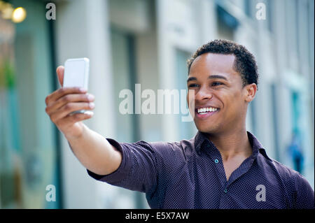 Junger Mann unter Smartphone Selfie auf Stadt Straße Stockfoto