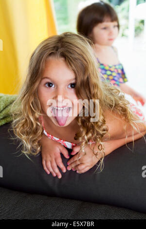 Porträt von zuversichtlich Mädchen ihre Zunge heraus Stockfoto