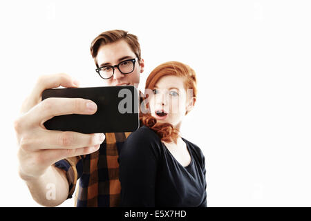 Studioaufnahme des jungen Paares posieren für Selfie auf smartphone Stockfoto