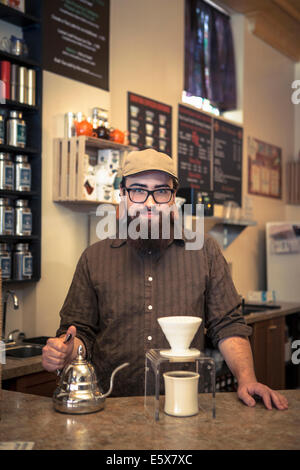 Porträt von Barista serviert Tee an Café-Zähler Stockfoto