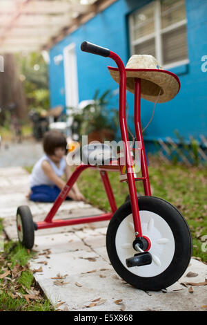 Dreirad vor vier Jahre altes Mädchen am Gartenweg Stockfoto