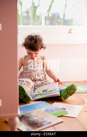 Weiblichen Kleinkind lesen Märchenbücher im Schlafzimmer Stockfoto