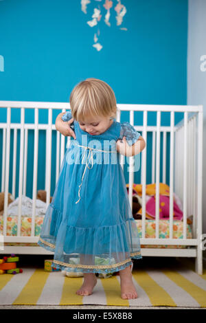 Weiblichen Kleinkind bewundern ihr Partykleid in Schlafzimmer Stockfoto