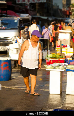 Chinesischer Mann Einkaufen auf den Wochenmarkt. Chun Yeung Street, Hong Kong. Stockfoto