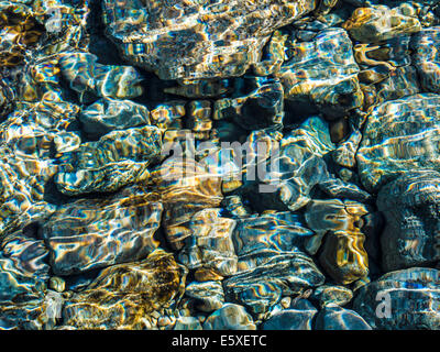 Abstrakte farbenfrohe Flachwasser Ripple Muster oben sonnenbeschienenen Kiesel im Fluss Bett, Schottland, UK Stockfoto