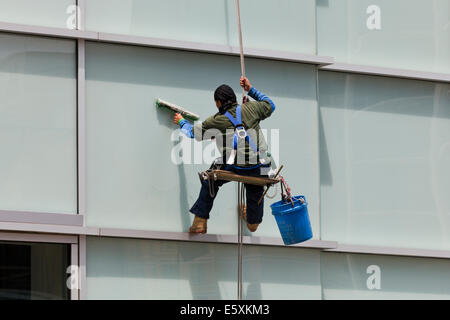 Hochhaus Fenster Reiniger sitzen in einem Bootsmann Stuhl - USA Stockfoto