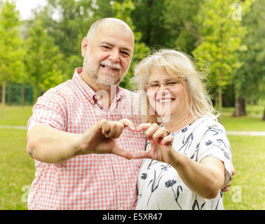 Romantische älteres Paar zeigt Herzform. Stockfoto