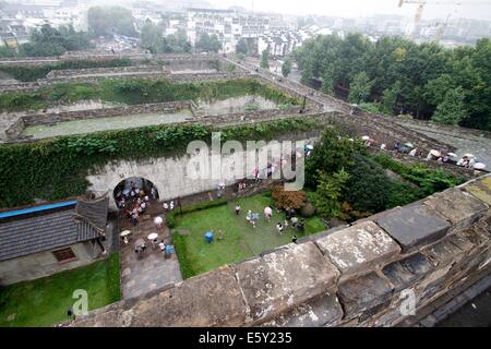 Nanjing. 8. August 2014. Touristen besuchen das Zhonghuamen Tor, eine Barbakane, die Teil der alten Stadtmauer von Nanjing, Hauptstadt der ostchinesischen Provinz Jiangsu, 8. August 2014 ist. Stadtmauer von Nanjing wurde von 1366 bis 1386, der frühen Jahre der Ming-Dynastie (1368-1644) erbaut. Einst Hauptstadt der Dynastie, Nanjing von vier Schichten aus Stein gemauerten Stadtmauern umschlossen sein. Nach sechs Jahrhunderten der natürlichen Erosion und menschliche Zerstörung mit der Absicht, die Länge der verbleibenden Stadtmauer 25 Kilometer heute beläuft sich, wodurch noch einen Weltrekord. © Xinhua/Alamy Live-Nachrichten Stockfoto