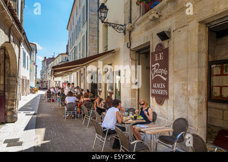 Belebten Straße Restaurant in schattigen schmale Straße servieren Mittagessen. Stockfoto