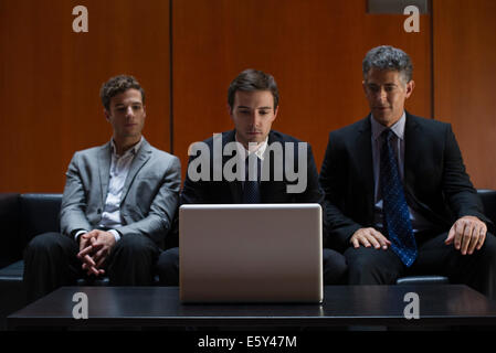 Geschäftspartner sitzen nebeneinander auf Sofa Blick auf Laptop-computer Stockfoto Geschäftspartner sitzen nebeneinander auf Sofa Blick auf Laptop-computer Stockfoto