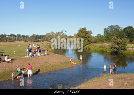 MENSCHEN, DIE AM FLUSSUFER ENTSPANNEN IM SOMMER Stockfoto