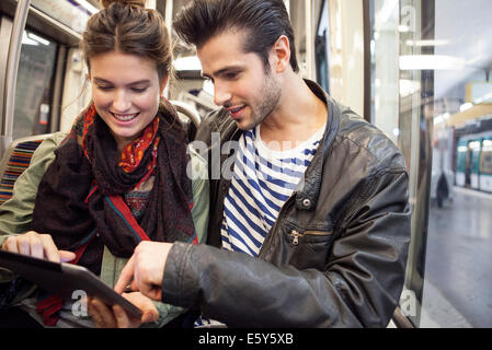 Junges Paar Reiten u digital-Tablette zusammen betrachten Stockfoto