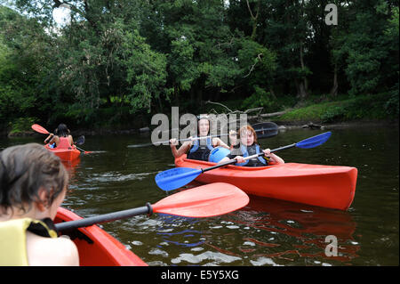 Junge Kinder mit ihren Eltern, Kanufahren auf dem Fluss Wye in der Nähe von Hay on Wye Stockfoto