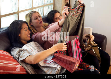 Junge Frauen auf der Suche im Inhalt von Einkaufstüten zusammen Stockfoto
