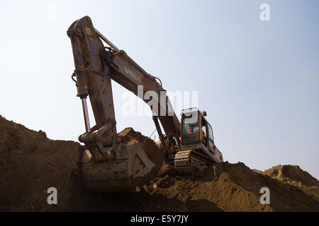 Ein kleiner Bagger wartet auf LKW an einer großen Tagebau Kupfer-Mine in Sambia zu beladen. Stockfoto