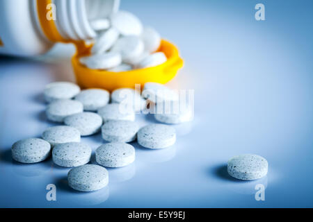 Pillen aus Pille Flasche auf blauem Hintergrund Stockfoto