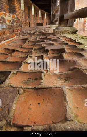 Worn-out roten Ziegeln im Korridor und inneren Hof der mittelalterlichen Burg Beersel, Belgien Stockfoto