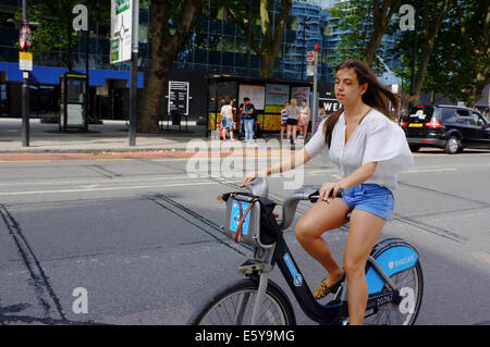 hübsche junge Frau mit dem Boris-Fahrrad Stockfoto
