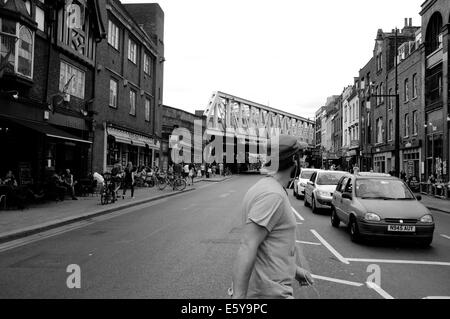 Man überquert die Straße vor Autos in East London Stockfoto
