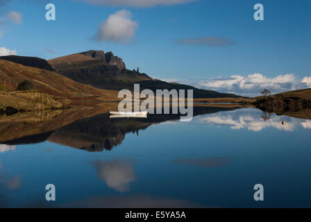 Spiegelreflexionen The Storr und der Old Man of Storr auf der Isle Of Skye, Schottland, mit einem Boot im Vordergrund Stockfoto