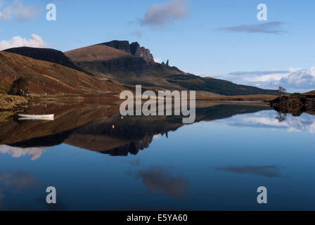 Spiegelreflexionen The Storr und der Old Man of Storr auf der Isle Of Skye, Schottland, mit einem Boot im Vordergrund Stockfoto